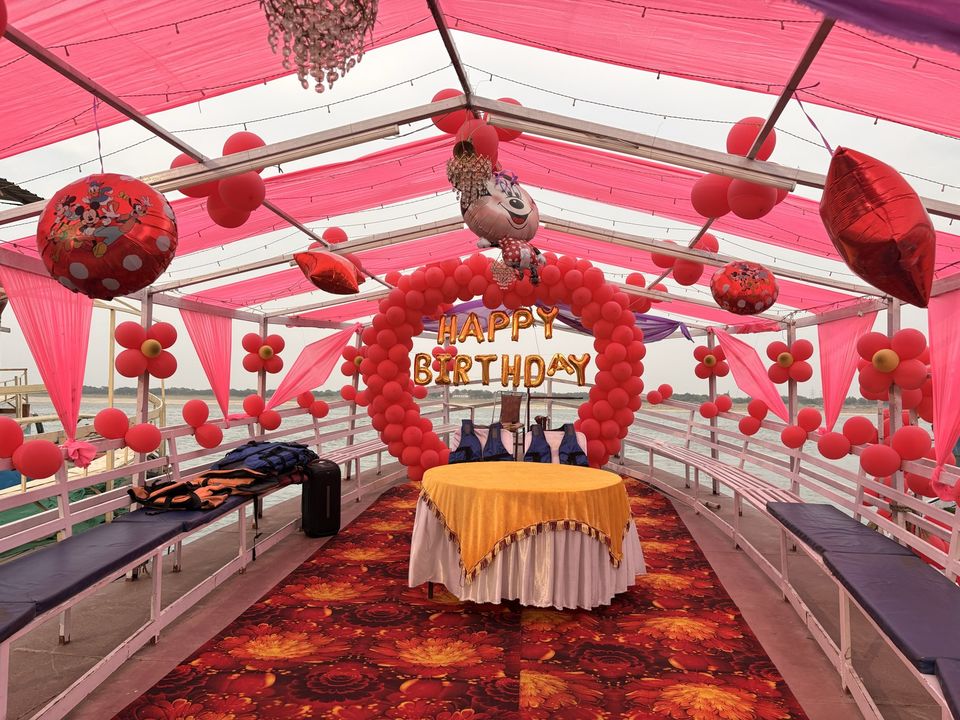 Birthday event on boat in Varanasi with balloon arch and cake table – Varanasi Boat Events